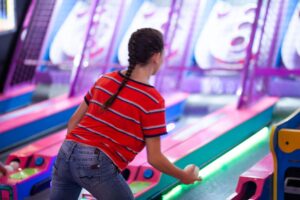 Girl bowling at Bridge Together Event